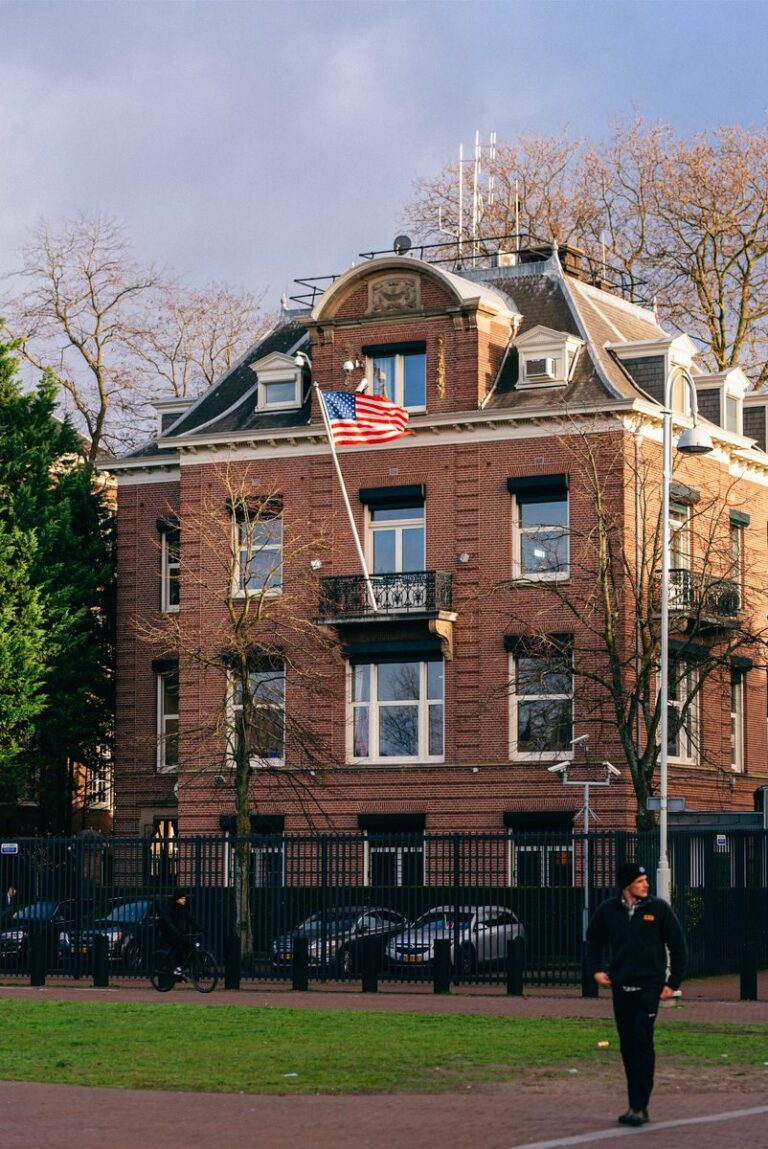 Discover a grand historic building adorned with the US flag in Amsterdam.