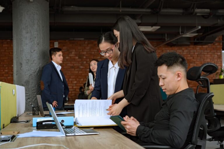Professional team engaged in discussion and collaboration in a modern office environment.